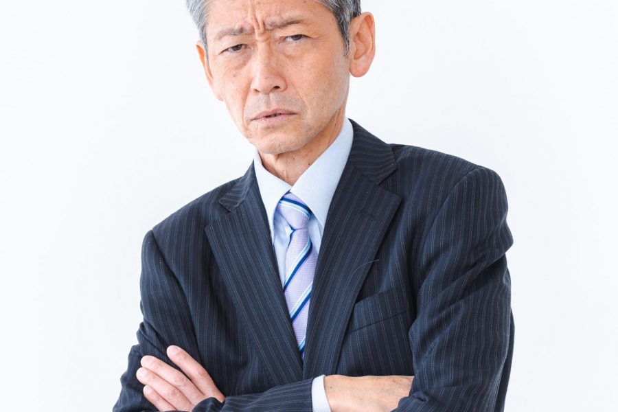 腕を組んで悩む人