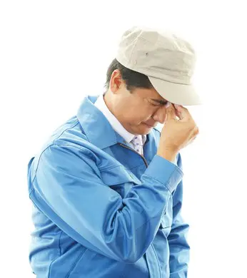 頭を抱えて悩む人の写真